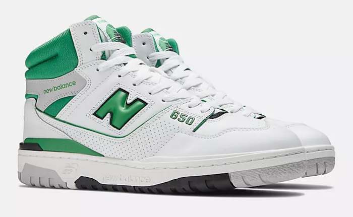 View of white and green New Balance shoes.